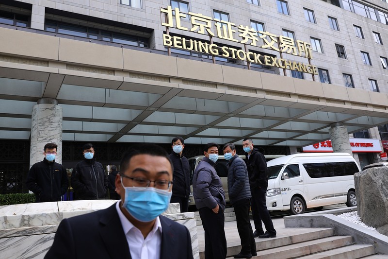 Men are seen near the new Beijing Stock Exchange building at the Financial Street, in Beijing, China, November 15, 2021. REUTERS/Tingshu Wang