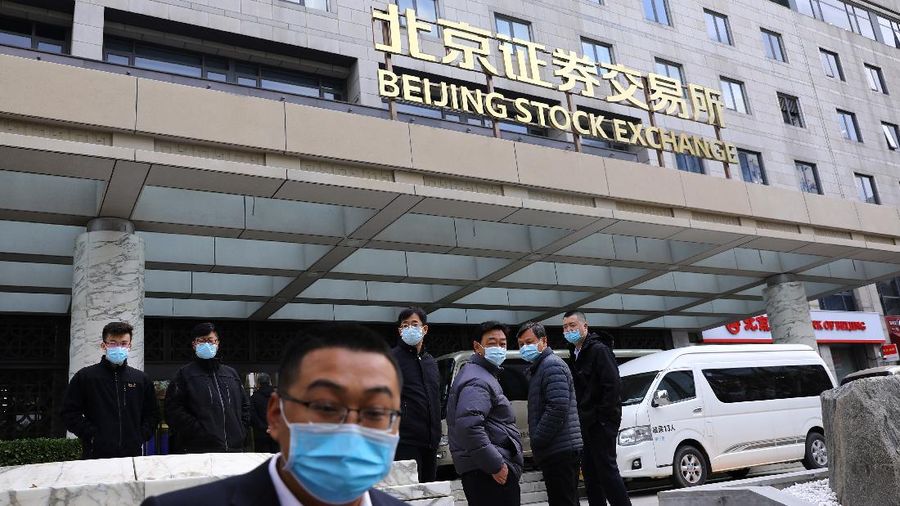 Men are seen near the new Beijing Stock Exchange building at the Financial Street, in Beijing, China, November 15, 2021. REUTERS/Tingshu Wang