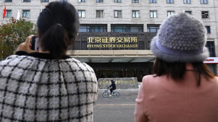 Men are seen near the new Beijing Stock Exchange building at the Financial Street, in Beijing, China, November 15, 2021. REUTERS/Tingshu Wang