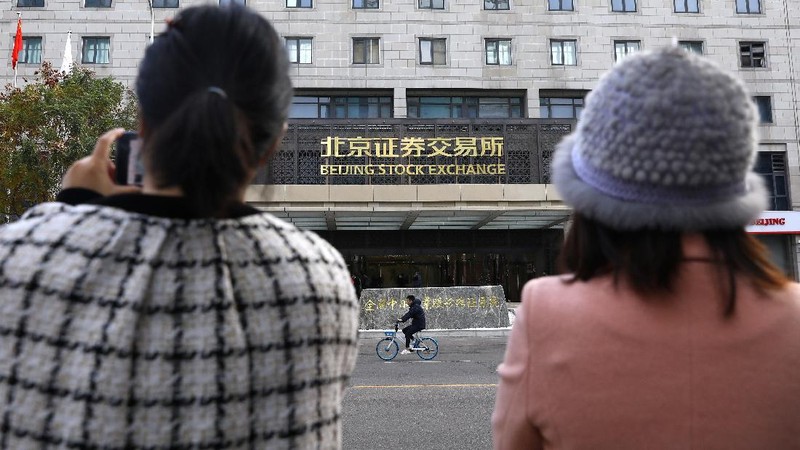Men are seen near the new Beijing Stock Exchange building at the Financial Street, in Beijing, China, November 15, 2021. REUTERS/Tingshu Wang