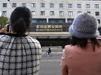 Media reporters stand near the new Beijing Stock Exchange building at the Financial Street, in Beijing, China, November 15, 2021. REUTERS/Tingshu Wang