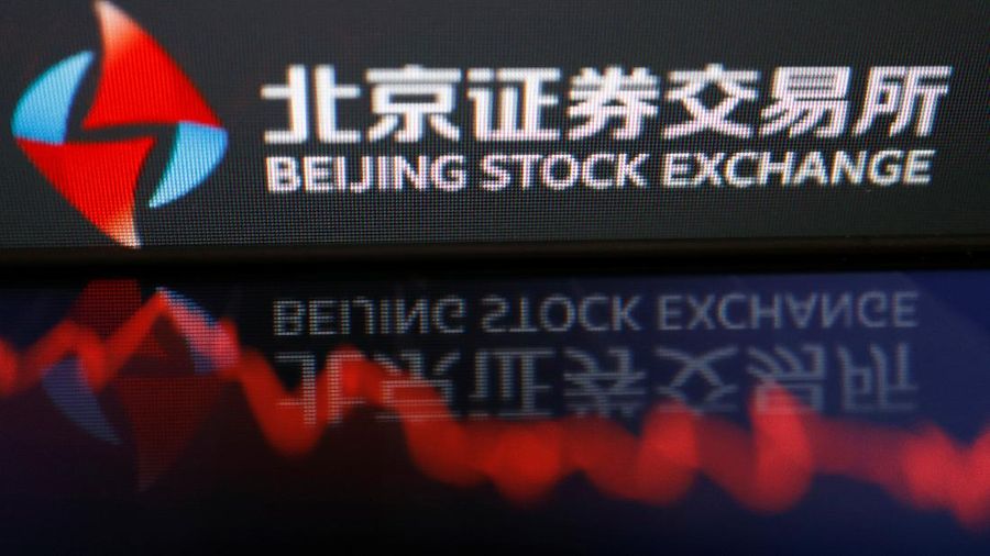 Men are seen near the new Beijing Stock Exchange building at the Financial Street, in Beijing, China, November 15, 2021. REUTERS/Tingshu Wang