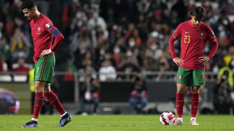 Serbia's Nikola Milenkovic, top, duels for the ball with Portugal's Cristiano Ronaldo, center left, and Portugal's Danilo Pereira, right, during the World Cup 2022 group A qualifying soccer match between Portugal and Serbia at the Luz stadium in Lisbon, Sunday, Nov 14, 2021. (AP Photo/Armando Franca)