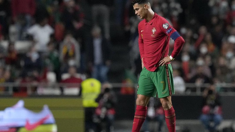 Serbia's Nikola Milenkovic, top, duels for the ball with Portugal's Cristiano Ronaldo, center left, and Portugal's Danilo Pereira, right, during the World Cup 2022 group A qualifying soccer match between Portugal and Serbia at the Luz stadium in Lisbon, Sunday, Nov 14, 2021. (AP Photo/Armando Franca)