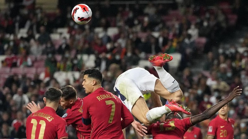 Serbia's Nikola Milenkovic, top, duels for the ball with Portugal's Cristiano Ronaldo, center left, and Portugal's Danilo Pereira, right, during the World Cup 2022 group A qualifying soccer match between Portugal and Serbia at the Luz stadium in Lisbon, Sunday, Nov 14, 2021. (AP Photo/Armando Franca)