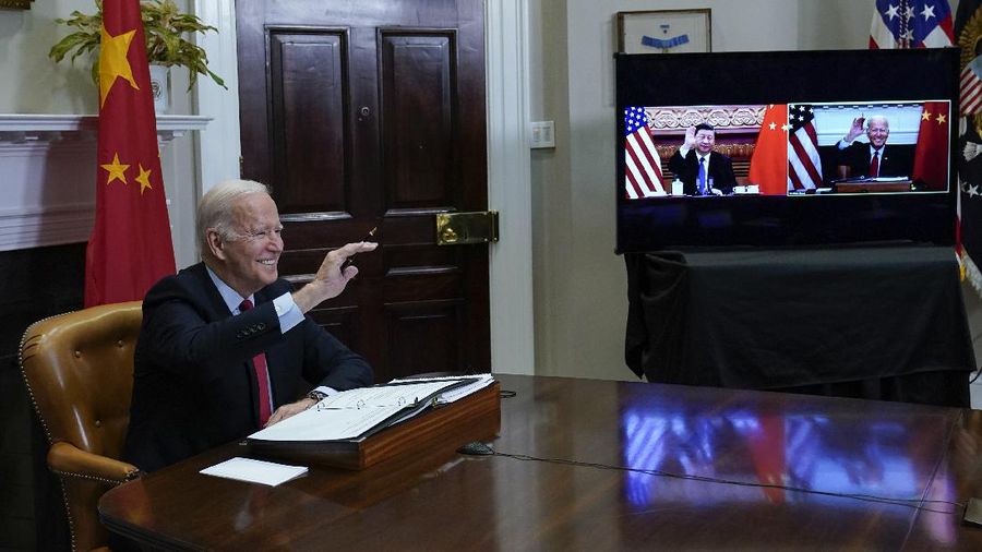 President Joe Biden waves as he meets virtually with Chinese President Xi Jinping from the Roosevelt Room of the White House in Washington, Monday, Nov. 15, 2021. (AP Photo/Susan Walsh)