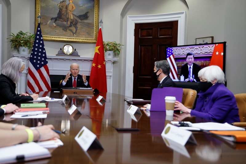 President Joe Biden waves as he meets virtually with Chinese President Xi Jinping from the Roosevelt Room of the White House in Washington, Monday, Nov. 15, 2021. (AP Photo/Susan Walsh)