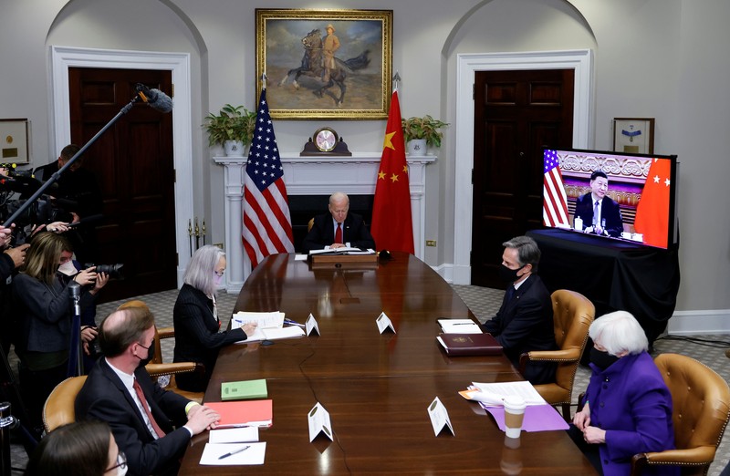 President Joe Biden waves as he meets virtually with Chinese President Xi Jinping from the Roosevelt Room of the White House in Washington, Monday, Nov. 15, 2021. (AP Photo/Susan Walsh)