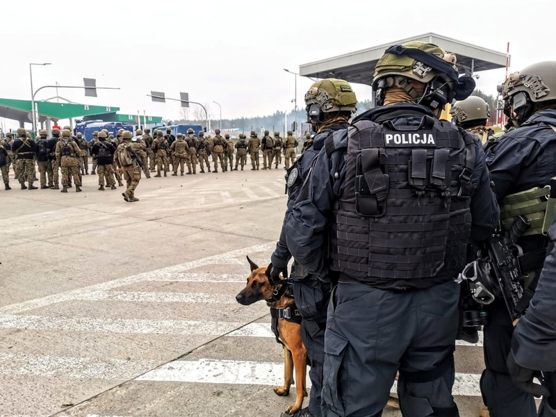 EUROPE-MIGRANTS/BELARUS-POLAND Polish law enforcement officers use water cannons, as migrants carry a log towards a fence at Kuznica - Bruzgi checkpoint, Poland, November 16, 2021. Policja Podlaska/Handout via REUTERS NO RESALES. NO ARCHIVES. MANDATORY CREDIT. THIS IMAGE HAS BEEN SUPPLIED BY A THIRD PARTY.