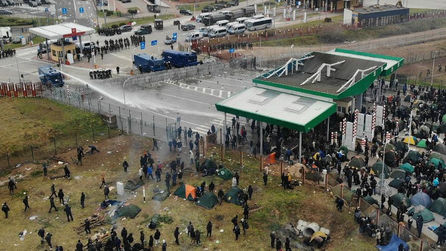 Polish law enforcement officers use a water cannon on migrants, who attempt to cross the Belarusian-Polish border at Bruzgi - Kuznica checkpoint in the Grodno region, Belarus November 16, 2021. Picture taken with a drone. Leonid Scheglov/BelTA/Handout via REUTERS ATTENTION EDITORS - THIS IMAGE HAS BEEN SUPPLIED BY A THIRD PARTY. NO RESALES. NO ARCHIVES. MANDATORY CREDIT.