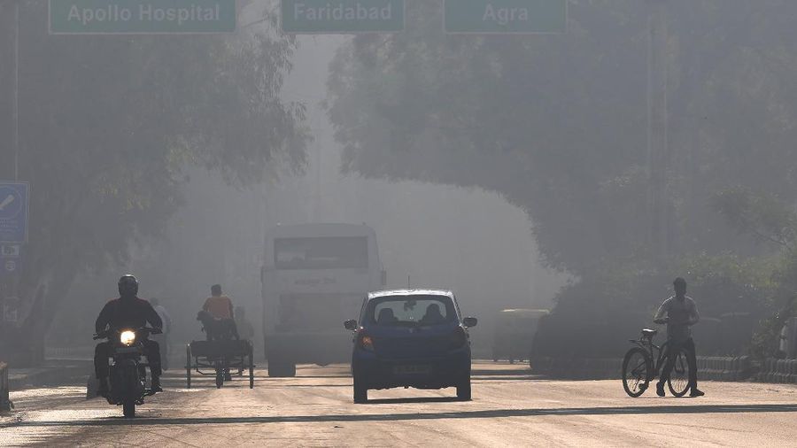 A motorcyclist drives on the wrong side of the road amidst morning haze and toxic smog in New Delhi, India, Wednesday, Nov. 17, 2021. Schools were closed indefinitely and some coal-based power plants shut down as the Indian capital and neighboring states invoked harsh measures Wednesday to combat air pollution after an order from the federal environment ministry panel. (AP Photo/Manish Swarup)
