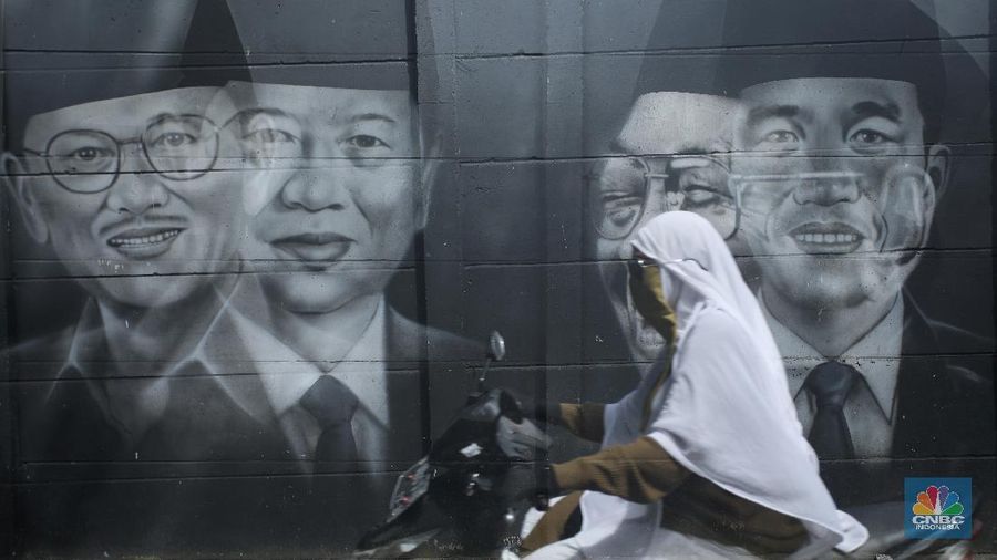 Warga melewati mural bergambar Presiden RI yang terpampang di tembok Kampung Sasak, Cipondoh Tangerang, Rabu (17/11/2021). Deretan wajah Presiden RI dari Soekarno hingga Joko Widodo menghiasi sudut kampung ini. (CNBC Indonesia/Andrean Kristianto)