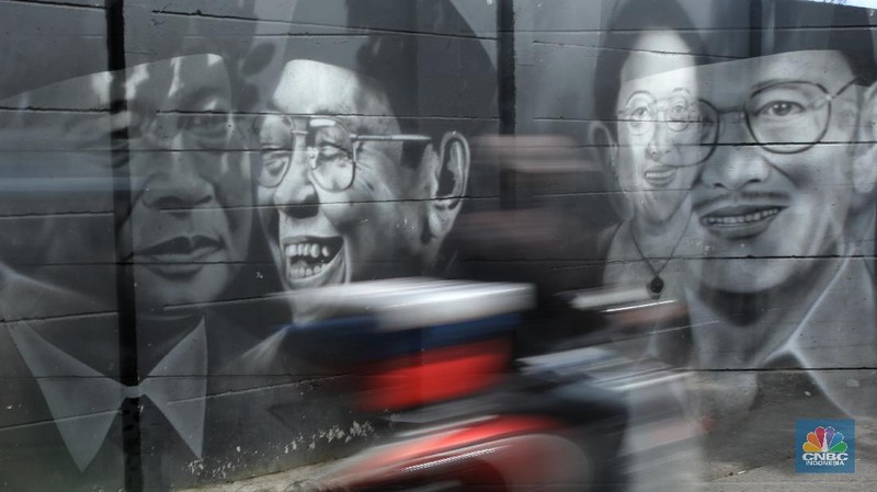 Warga melewati mural bergambar Presiden RI yang terpampang di tembok Kampung Sasak, Cipondoh Tangerang, Rabu (17/11/2021). Deretan wajah Presiden RI dari Soekarno hingga Joko Widodo menghiasi sudut kampung ini. (CNBC Indonesia/Andrean Kristianto)