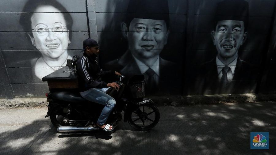 Warga melewati mural bergambar Presiden RI yang terpampang di tembok Kampung Sasak, Cipondoh Tangerang, Rabu (17/11/2021). Deretan wajah Presiden RI dari Soekarno hingga Joko Widodo menghiasi sudut kampung ini. (CNBC Indonesia/Andrean Kristianto)
