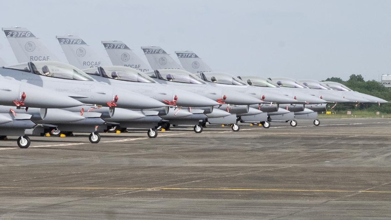 A Taiwanese Air Force flag bearer passes by one of the newly commissioned upgraded F-16V fighter jets at Air Force base in Chiayi in southwestern Taiwan Thursday, Nov. 18, 2021. Taiwan has deployed the most advanced version of the F-16 fighter jet in its Air Force, as the island steps up its defense capabilities in the face of continuing threats from China. (AP Photo/Johnson Lai)
