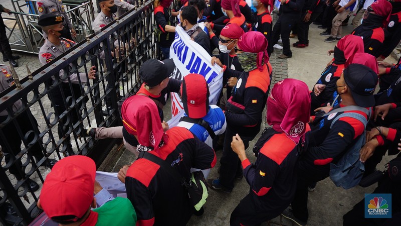 Ratusan buruh dari Konfederasi Serikat Pekerja Indonesia (KSPI) menggelar aksi di depan Kantor Balai Kota Jakarta, Jalan Medan Merdeka Selatan, Jakarta Pusat, Jumat (19/11/2021). Para buruh berkumpul di depan Balai Kota dengan membawa sejumlah spanduk yang bertuliskan 'Naikan UMP/UMSP 2022 sebesar 10 persen'. Pantauan dilokasi aksi buruh sempat terjadi dorong mendorong untuk melewati pagar yang dikawal oleh pihak kepolisian yang berjaga.
 (CNBC Indonesia/ Tri Susilo)