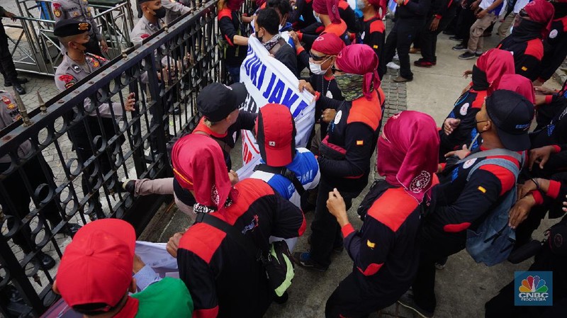 Ratusan buruh dari Konfederasi Serikat Pekerja Indonesia (KSPI) menggelar aksi di depan Kantor Balai Kota Jakarta, Jalan Medan Merdeka Selatan, Jakarta Pusat, Jumat (19/11/2021). Para buruh berkumpul di depan Balai Kota dengan membawa sejumlah spanduk yang bertuliskan 'Naikan UMP/UMSP 2022 sebesar 10 persen'. Pantauan dilokasi aksi buruh sempat terjadi dorong mendorong untuk melewati pagar yang dikawal oleh pihak kepolisian yang berjaga.
 (CNBC Indonesia/ Tri Susilo)