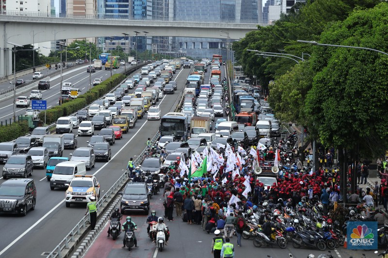 Konfederasi Serikat Pekerja Indonesia (KSPI) menggelar aksi di depan Kementerian Ketenagakerjaan (Kemnaker RI), Jumat (19/11/2021). Konfederasi Serikat Pekerja Indonesia (KSPI) tetap menginginkan Upah Minimum Provinsi (UMP) di tahun 2022 naik 7% - 10%. Bahkan mengancam akan melakukan aksi mogok nasional bila tuntutan tak dipenuhi.  Pantauan dilokasi Lalu lintas di depan Kemenaker mengalami kemacetan. Kendaraan terlihat antre dari atas flyover Kuningan, Jakarta Selatan. (CNBC Indonesia/ Tri Susilo)
