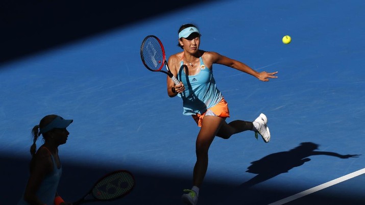 Peng Shuai, right, of China makes a forehand return as partner Andrea Hlavackova of the Czech Republic watches during the women's doubles final against Bethanie Mattek-Sands of the U.S. and Lucie Safarova of the Czech Republic at the Australian Open tennis championships in Melbourne, Australia, Friday, Jan. 27, 2017. (AP Photo/Kin Cheung)