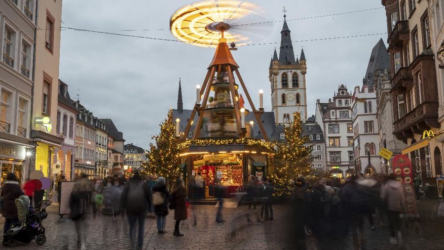 People visit the Christmas market in the city centre of Trier, Germany, Friday, Nov. 19, 2021. The head of Germany’s disease control agency said Friday that the country has entered into a “nationwide state of emergency” because of surging coronavirus infections. The head of the Robert Koch Institute said regular medical care cannot be guaranteed anymore in some parts of the country because hospitals and intensive care wards are overstretched. (Harald Tittel/dpa via AP)