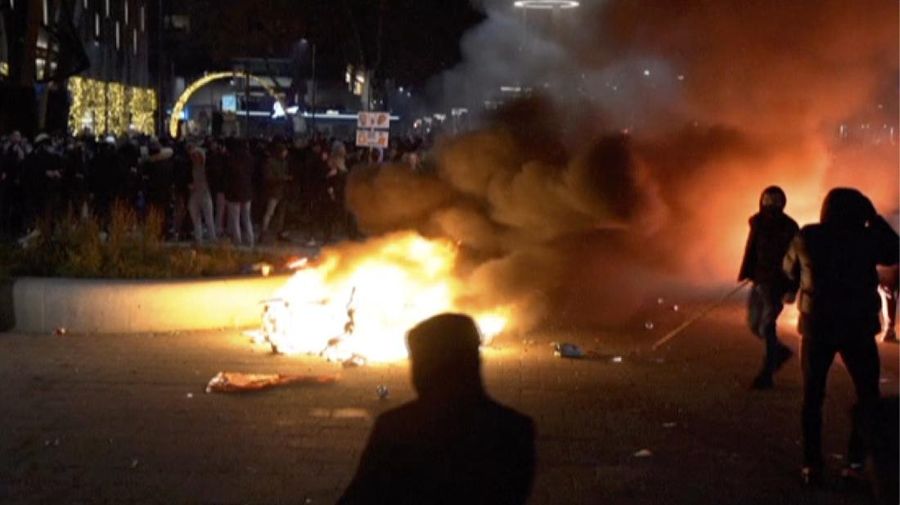 In this image taken from video, demonstrators protest against government restrictions due to the coronavirus pandemic, Friday, Nov. 19, 2021, in Rotterdam, Netherlands. Police fired warning shots, injuring an unknown number of people, as riots broke out Friday night in downtown Rotterdam at a demonstration against plans by the government to restrict access for unvaccinated people to some venues. (Media TV Rotterdam via AP)