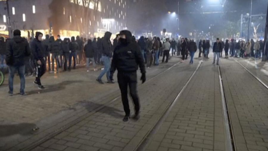 In this image taken from video, demonstrators protest against government restrictions due to the coronavirus pandemic, Friday, Nov. 19, 2021, in Rotterdam, Netherlands. Police fired warning shots, injuring an unknown number of people, as riots broke out Friday night in downtown Rotterdam at a demonstration against plans by the government to restrict access for unvaccinated people to some venues. (Media TV Rotterdam via AP)