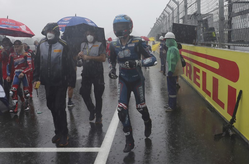 Hujan Sebabkan Penundaan Race 1 Kejuaraan Dunia Superbike di Sirkuit Internasional Mandalika Seorang mekanik mendorong sepeda motor ke paddock di tengah hujan lebat menjelang Race 1 Kejuaraan Dunia Superbike di Sirkuit Internasional Mandalika di Mandalika, Pulau Lombok, Indonesia, Sabtu, 20 November 2021. Kondisi cuaca pada hari Sabtu menyebabkan penundaan Race 1 hingga Minggu, 21 November. (AP Photo/Achmad Ibrahim)