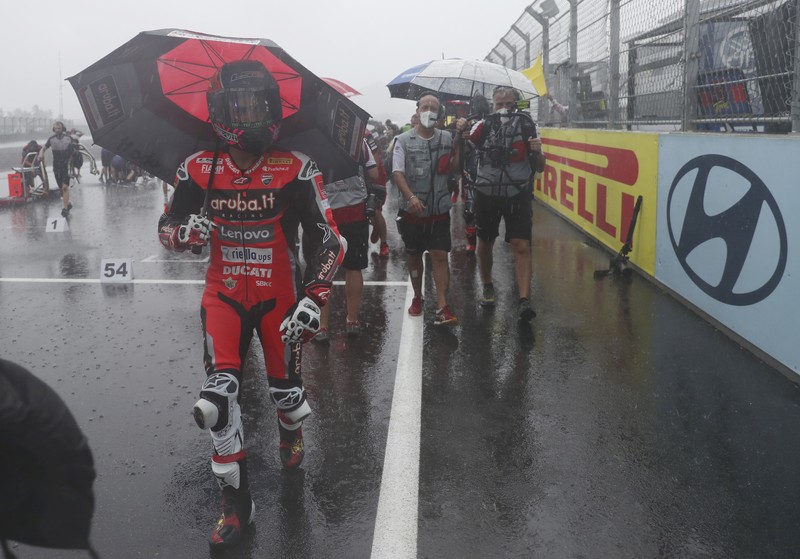 Hujan Sebabkan Penundaan Race 1 Kejuaraan Dunia Superbike di Sirkuit Internasional Mandalika Seorang mekanik mendorong sepeda motor ke paddock di tengah hujan lebat menjelang Race 1 Kejuaraan Dunia Superbike di Sirkuit Internasional Mandalika di Mandalika, Pulau Lombok, Indonesia, Sabtu, 20 November 2021. Kondisi cuaca pada hari Sabtu menyebabkan penundaan Race 1 hingga Minggu, 21 November. (AP Photo/Achmad Ibrahim)