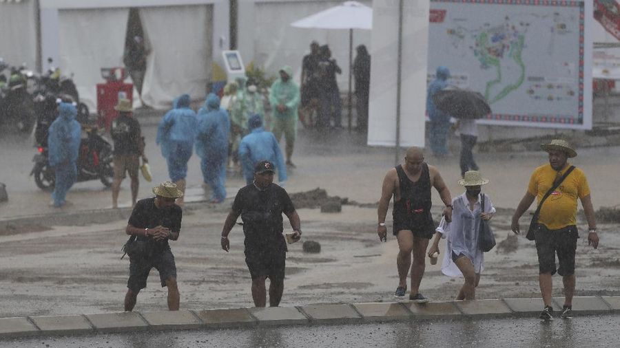 Seorang mekanik mendorong sepeda motor ke paddock di tengah hujan lebat menjelang Race 1 Kejuaraan Dunia Superbike di Sirkuit Internasional Mandalika di Mandalika, Pulau Lombok, Indonesia, Sabtu, 20 November 2021. Kondisi cuaca pada hari Sabtu menyebabkan penundaan Race 1 hingga Minggu, 21 November. (AP Photo/Achmad Ibrahim)