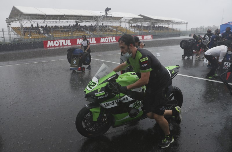 Hujan Sebabkan Penundaan Race 1 Kejuaraan Dunia Superbike di Sirkuit Internasional Mandalika Seorang mekanik mendorong sepeda motor ke paddock di tengah hujan lebat menjelang Race 1 Kejuaraan Dunia Superbike di Sirkuit Internasional Mandalika di Mandalika, Pulau Lombok, Indonesia, Sabtu, 20 November 2021. Kondisi cuaca pada hari Sabtu menyebabkan penundaan Race 1 hingga Minggu, 21 November. (AP Photo/Achmad Ibrahim)