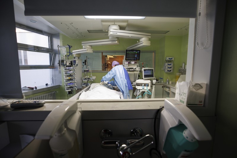 Lorenz Nowak, head physician of the Clinic for Intensive Care Medicine, treats a COVID-19 patient in the ICU of the Asklepios Clinic, in Gauting, Germany, Friday, Nov. 19, 2021. The head of Germany’s disease control agency said Friday that the country has entered into a “nationwide state of emergency” because of surging coronavirus infections. The head of the Robert Koch Institute said regular medical care cannot be guaranteed anymore in some parts of the country because hospitals and intensive care wards are overstretched. (Matthias Balk/dpa via AP)