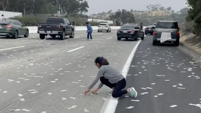 Warga berhamburan keluar mobil untuk memunguti uang dari 'hujan duit' di tol California, Amerika Serikat. Akibat kehebohan ini pun memicu kemacetan. (Instagram @demibagby)
