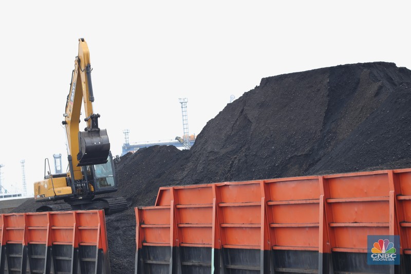 Pekerja membersihkan sisa-sisa batu bara yang berada di luar kapal tongkang pada saat bongkar muat di Pelabuhan Tanjung Priok, Jakarta, Senin (22/11/2021). Pemerintah Indonesia berambisi untuk mengurangi besar-besaran konsumsi batu bara di dalam negeri, bahkan tak mustahil bila meninggalkannya sama sekali. Hal ini tak lain demi mencapai target netral karbon pada 2060 atau lebih cepat, seperti yang dikampanyekan banyak negara di dunia. (CNBC Indonesia/ Tri Susilo)