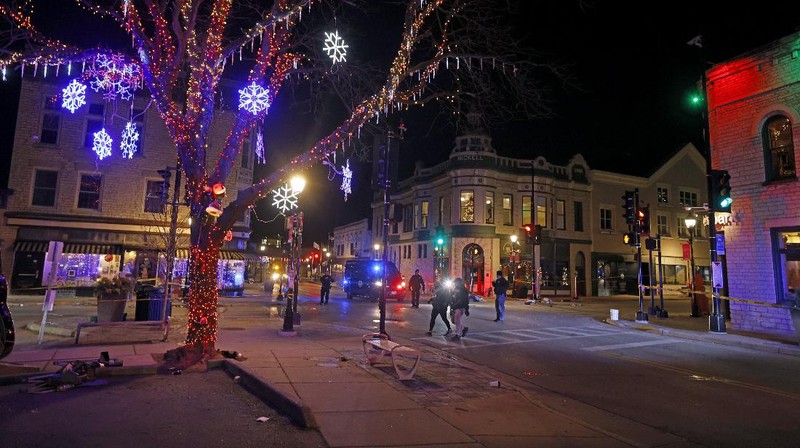 A red SUV speeds past attendees moments before plowing into a crowd at a Christmas parade in Waukesha, Wisconsin, U.S., in this still image taken from a November 21, 2021 social media video. CITY OF WAUKESHA/Facebook/via REUTERS THIS IMAGE HAS BEEN SUPPLIED BY A THIRD PARTY. MANDATORY CREDIT. NO RESALES. NO ARCHIVES.