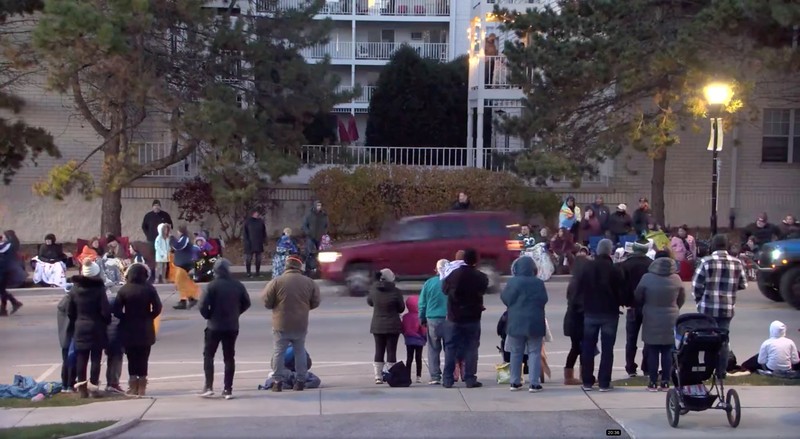 A red SUV speeds past attendees moments before plowing into a crowd at a Christmas parade in Waukesha, Wisconsin, U.S., in this still image taken from a November 21, 2021 social media video. CITY OF WAUKESHA/Facebook/via REUTERS THIS IMAGE HAS BEEN SUPPLIED BY A THIRD PARTY. MANDATORY CREDIT. NO RESALES. NO ARCHIVES.