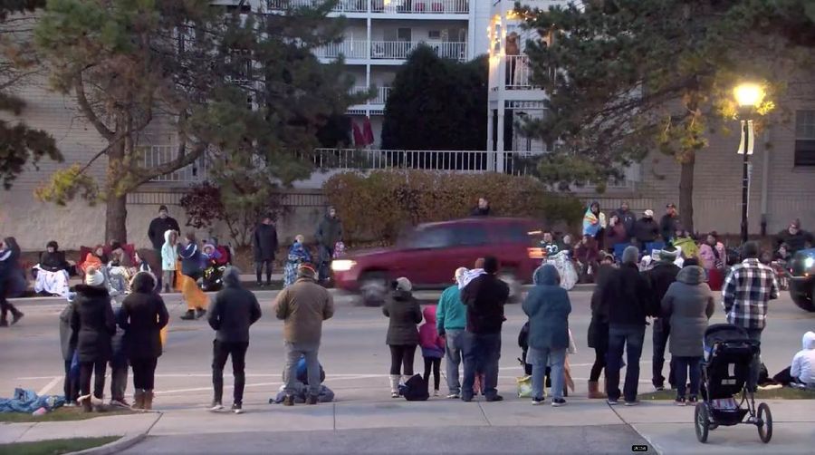 A red SUV speeds past attendees moments before plowing into a crowd at a Christmas parade in Waukesha, Wisconsin, U.S., in this still image taken from a November 21, 2021 social media video. CITY OF WAUKESHA/Facebook/via REUTERS THIS IMAGE HAS BEEN SUPPLIED BY A THIRD PARTY. MANDATORY CREDIT. NO RESALES. NO ARCHIVES.
