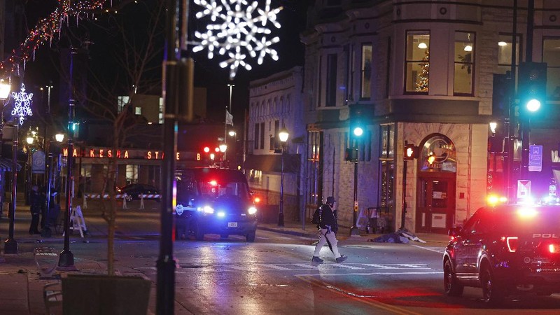 A red SUV speeds past attendees moments before plowing into a crowd at a Christmas parade in Waukesha, Wisconsin, U.S., in this still image taken from a November 21, 2021 social media video. CITY OF WAUKESHA/Facebook/via REUTERS THIS IMAGE HAS BEEN SUPPLIED BY A THIRD PARTY. MANDATORY CREDIT. NO RESALES. NO ARCHIVES.