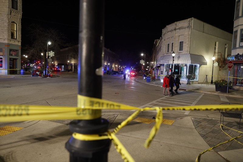 A red SUV speeds past attendees moments before plowing into a crowd at a Christmas parade in Waukesha, Wisconsin, U.S., in this still image taken from a November 21, 2021 social media video. CITY OF WAUKESHA/Facebook/via REUTERS THIS IMAGE HAS BEEN SUPPLIED BY A THIRD PARTY. MANDATORY CREDIT. NO RESALES. NO ARCHIVES.