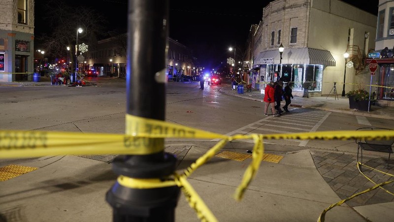 A red SUV speeds past attendees moments before plowing into a crowd at a Christmas parade in Waukesha, Wisconsin, U.S., in this still image taken from a November 21, 2021 social media video. CITY OF WAUKESHA/Facebook/via REUTERS THIS IMAGE HAS BEEN SUPPLIED BY A THIRD PARTY. MANDATORY CREDIT. NO RESALES. NO ARCHIVES.