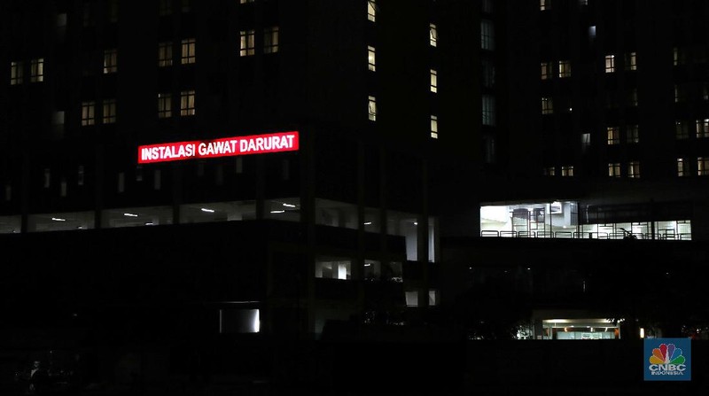 Sejumlah warga berbincang dengan latar belakang Gedung Wisma Atlet, Kemayoran yang gelap, Selasa (23/11/2021). Jumlah pasien di Rumah Sakit Darurat Covid-19 (RSDC) Wisma Atlet, Kemayoran, Jakarta, terus berkurang dalam beberapa waktu terakhir.
Dari pantauan CNBC Indonesia dilokasi hanya beberapa keluarga yang datang hilir mudik untuk menjemput keluarga pasien Covid-19 yang memang sudah terindikasi negatif dan diizinkan untuk pulang. 
Menurut penjaga pintu darurat yang tidak ingin disebutkan namanya mengatakan 