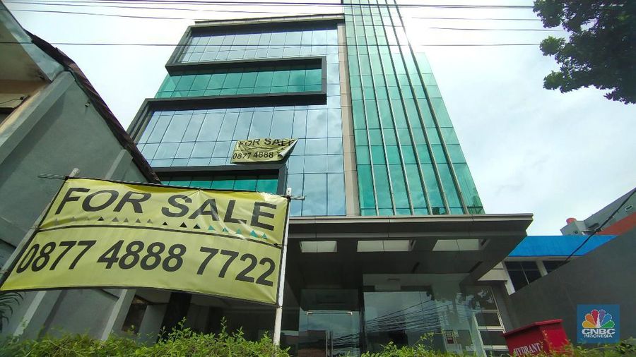 Pengendara melewati spanduk gedung yang dijual dikawasan, Jakarta, Selasa (23/11/2021). Fenomena maraknya penjualan gedung perkantoran DKI Jakarta dapat terpotret dari marketplace seperti OLX, salah satunya sebuah gedung yang berlokasi didi Mampang Prapatan, Jakarta.  (CNBC Indonesia/ Tri Susilo)