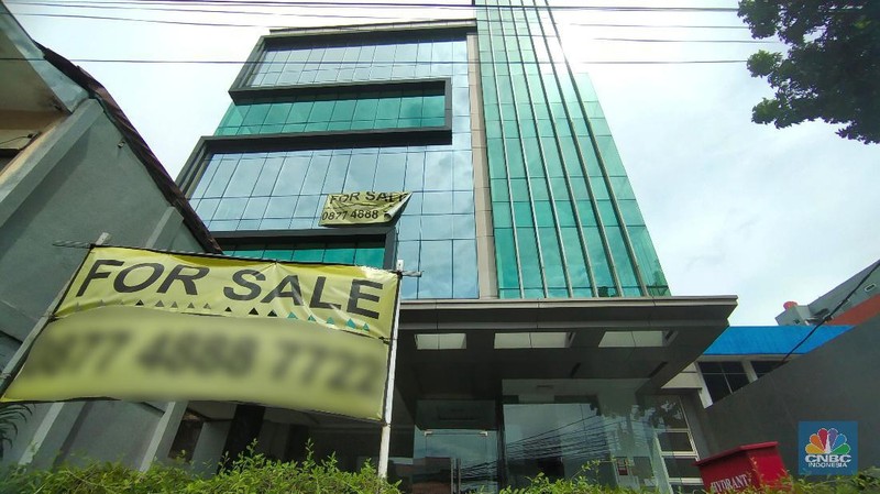 Pengendara melewati spanduk gedung yang dijual dikawasan, Jakarta, Selasa (23/11/2021). Fenomena maraknya penjualan gedung perkantoran DKI Jakarta dapat terpotret dari marketplace seperti OLX, salah satunya sebuah gedung yang berlokasi didi Mampang Prapatan, Jakarta.  (CNBC Indonesia/ Tri Susilo)