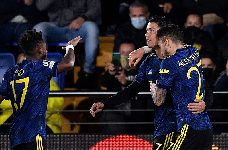 Pemain Manchester United Cristiano Ronaldo merayakan gol pertamanya bersama Alex Telles di pertandingan sepak bola Grup F Liga Champions antara Villarreal dan Manchester United Pemain Manchester United Cristiano Ronaldo merayakan gol pertamanya bersama Alex Telles selama pertandingan sepak bola Grup F Liga Champions antara Villarreal dan Manchester United di stadion Ceramica di Villarreal, Spanyol, Selasa, 23 November 2021. (REUTERS/Pablo Morano)