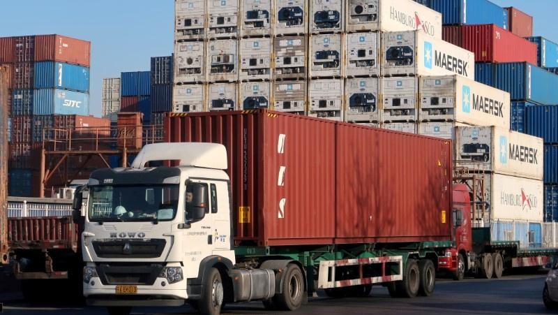 FILE PHOTO: A worker drives a truck carrying a container at a logistics center near Tianjin port, in Tianjin, China December 12, 2019.   REUTERS/Yilei Sun/File Photo