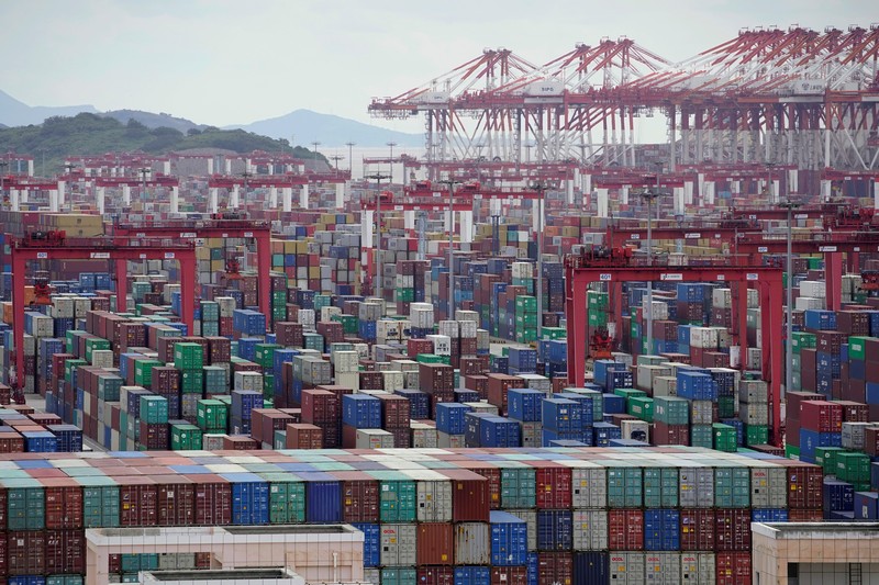 FILE PHOTO: A worker drives a truck carrying a container at a logistics center near Tianjin port, in Tianjin, China December 12, 2019.   REUTERS/Yilei Sun/File Photo
