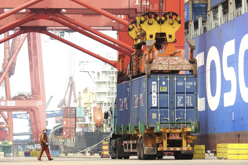 FILE PHOTO: A worker drives a truck carrying a container at a logistics center near Tianjin port, in Tianjin, China December 12, 2019.   REUTERS/Yilei Sun/File Photo