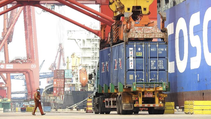 In this April 14, 2020, photo released by China's Xinhua News Agency, a worker wears a facemask as he monitors cargo being unloaded from a container ship at a port in Lianyungang in eastern China's Jiangsu Province. China has reported its biggest economic decline since the 1970s as it fought the coronavirus in the first quarter of the year. (Geng Yuhe/Xinhua via AP)
