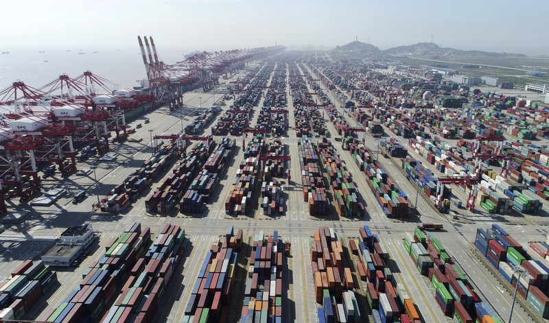 FILE PHOTO: A worker drives a truck carrying a container at a logistics center near Tianjin port, in Tianjin, China December 12, 2019.   REUTERS/Yilei Sun/File Photo
