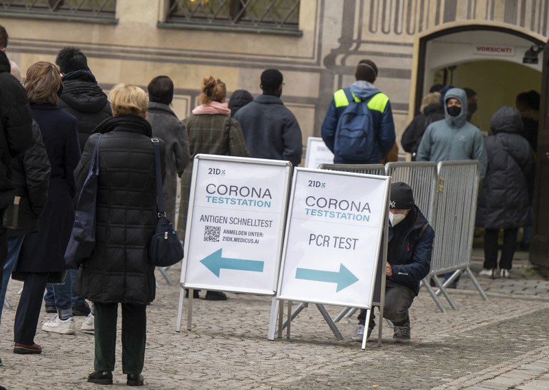 A sign indicating COVID-19 restrictions of mandatory masks hangs on a post along a pedestrian street in Flensburg, Germany, Wednesday, Nov. 24, 2021.(Roland Weihrauch/dpa via AP)