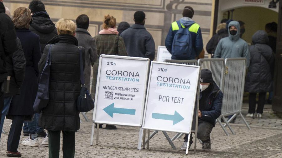 A sign indicating COVID-19 restrictions of mandatory masks hangs on a post along a pedestrian street in Flensburg, Germany, Wednesday, Nov. 24, 2021.(Roland Weihrauch/dpa via AP)